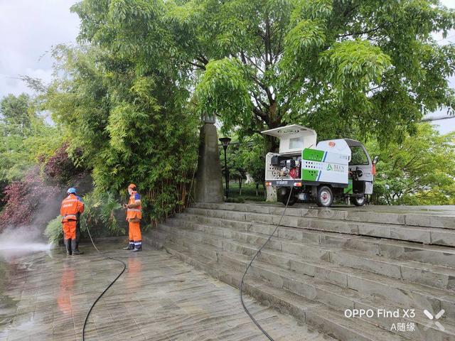 安岳紫竹公园环卫工人正在冲洗石板上的青苔